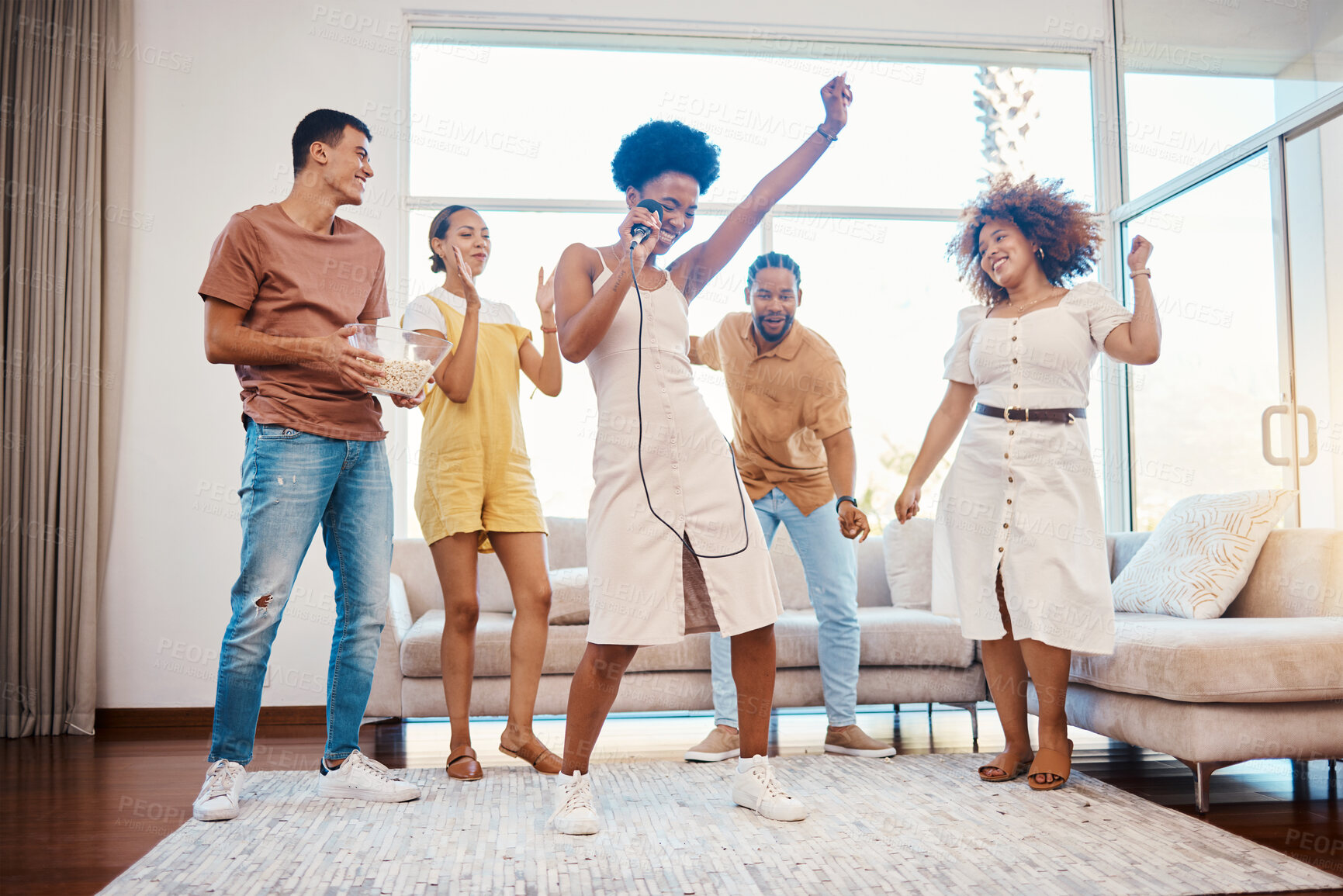 Buy stock photo Sing, energy and friends dancing in the living room with a microphone to music, playlist or radio. Happy, diversity and young people moving, bonding and having fun together with karaoke at home.