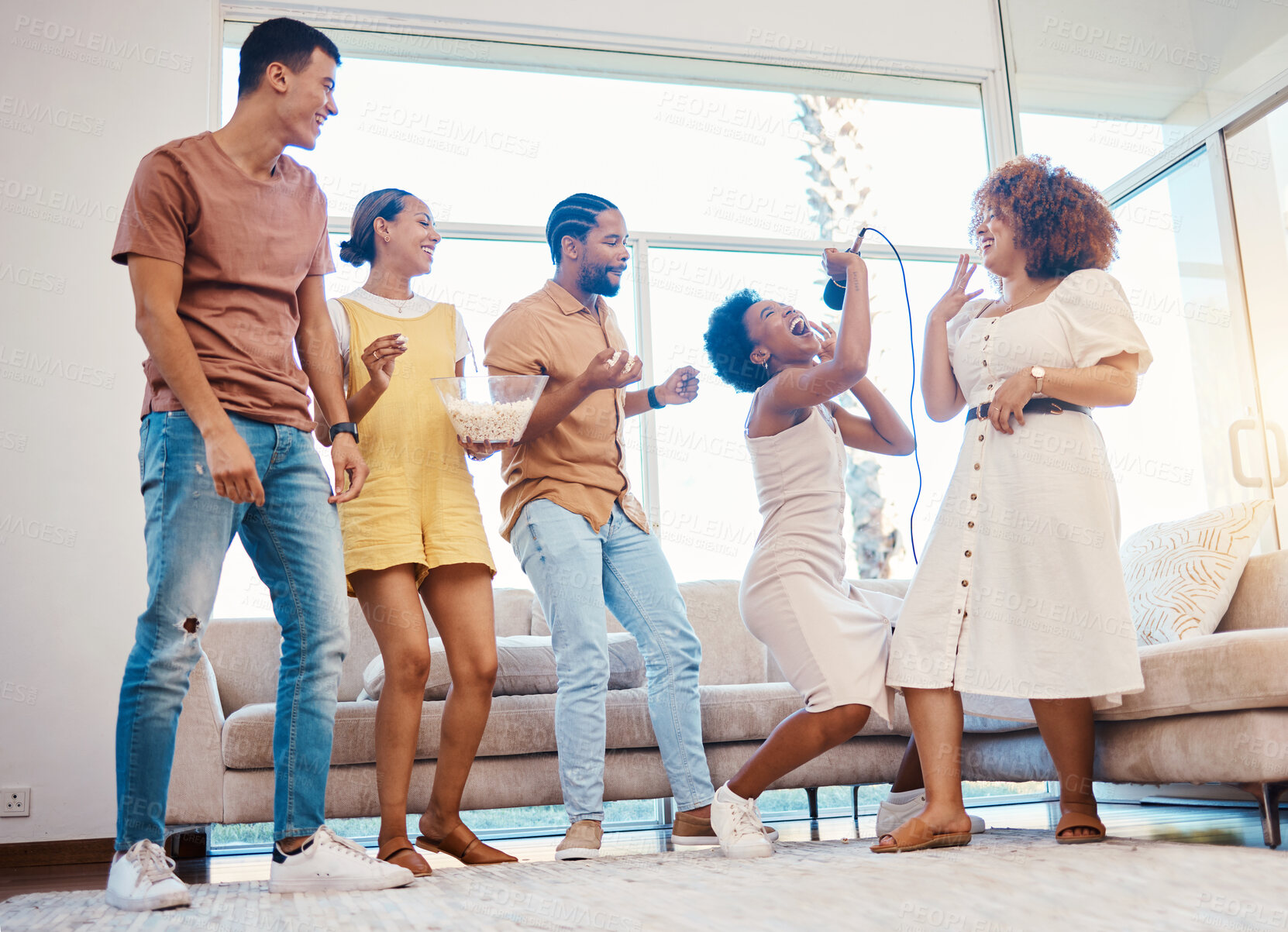 Buy stock photo Karaoke, entertainment and friends singing in the living room with a microphone to music, playlist or radio. Happy, diversity and young people dancing, bonding and having fun together at an apartment