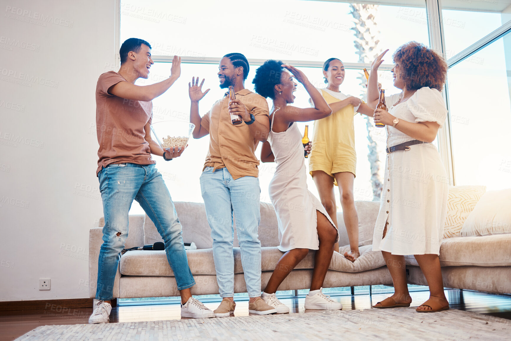 Buy stock photo Friends, excited and beer to celebrate at a house with happiness, fun and a high five in a lounge. Diversity, alcohol and party with men and women together for drinks, gathering or reunion at home