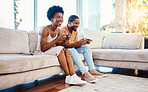 Gamer, funny and a black couple on a sofa in the living room of their home together for bonding. Love, fun or leisure with a gaming man and woman playing online using a console in their house