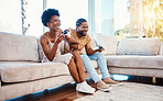 Gaming, funny and a black couple on a sofa in the living room of their home together for bonding. Love, fun or leisure with a gamer man and woman playing online using a console in their house