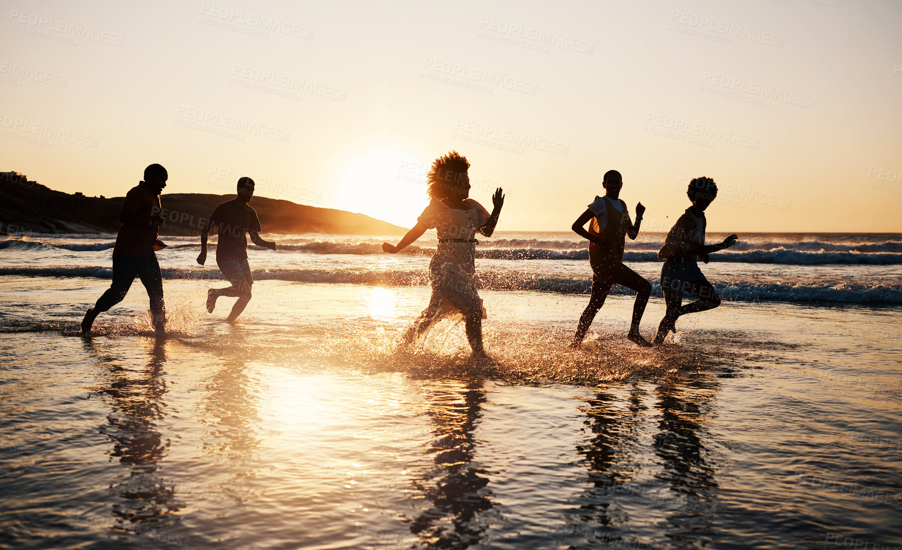 Buy stock photo Sunset, beach and friends with freedom, running and having fun in water together on summer vacation. Ocean, silhouette and group of people at the sea for holiday, bond and travel celebration in Bali