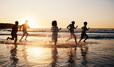 Buy stock photo Sunrise, beach and friends with freedom, running and having fun in water together on summer vacation. Ocean, silhouette and group of people at the sea for holiday, bond and travel celebration in Bali