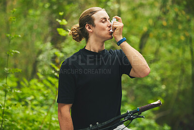 Buy stock photo Asthma, fitness and man cyclist on a bicycle in a forest with breathing medical emergency during exercise or training. Outdoor, lung support and athlete with inhaler in nature for workout or wellness