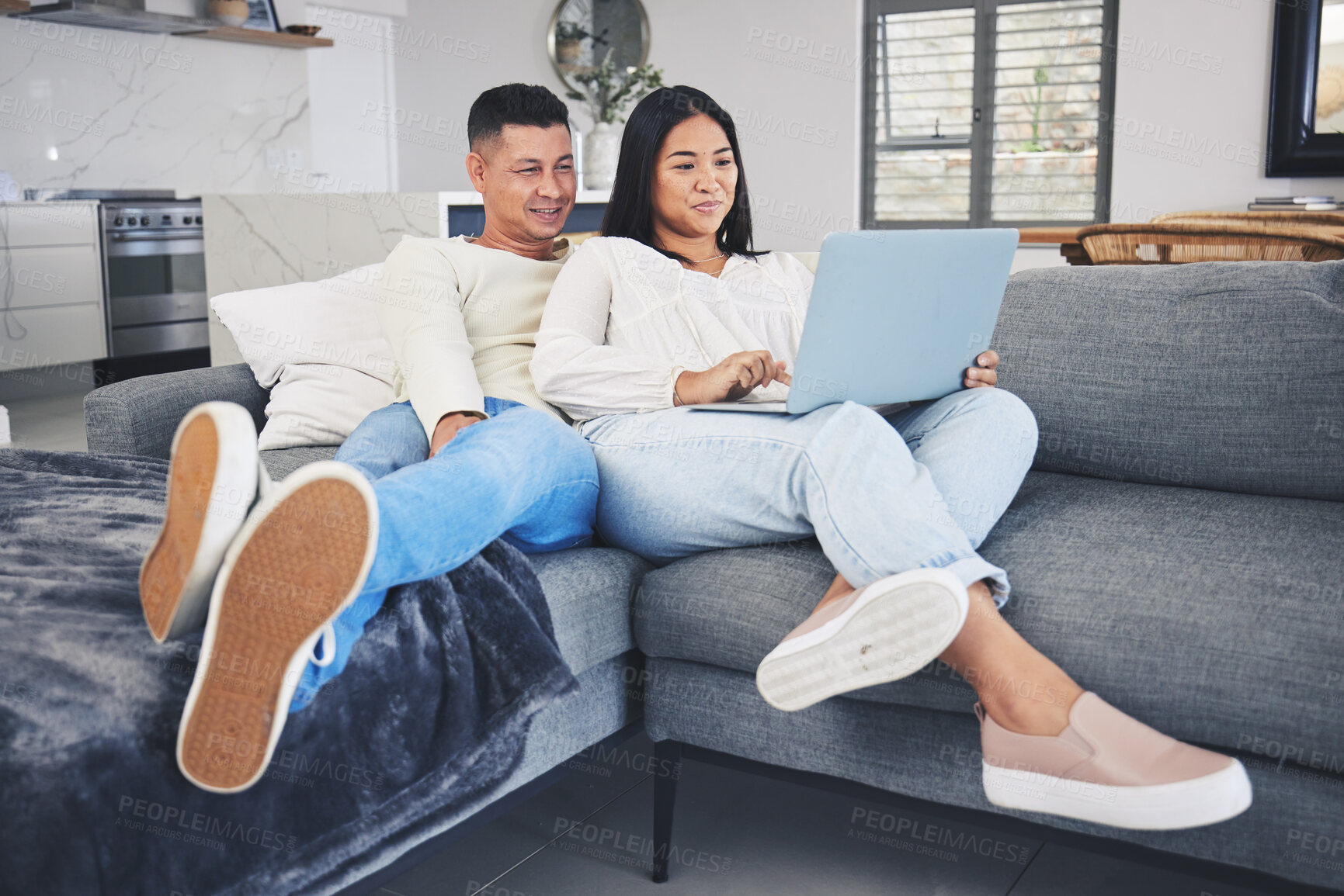 Buy stock photo Laptop, online shopping and couple relaxing on a sofa in the living room of their modern house. Happy, technology and young man and woman networking or browsing on the internet with computer at home.