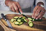 Cooking, food and hands with cucumber in kitchen on wooden board for cutting, meal prep and nutrition. Healthy diet, ingredients and person with vegetables for vegetarian dinner, lunch and salad