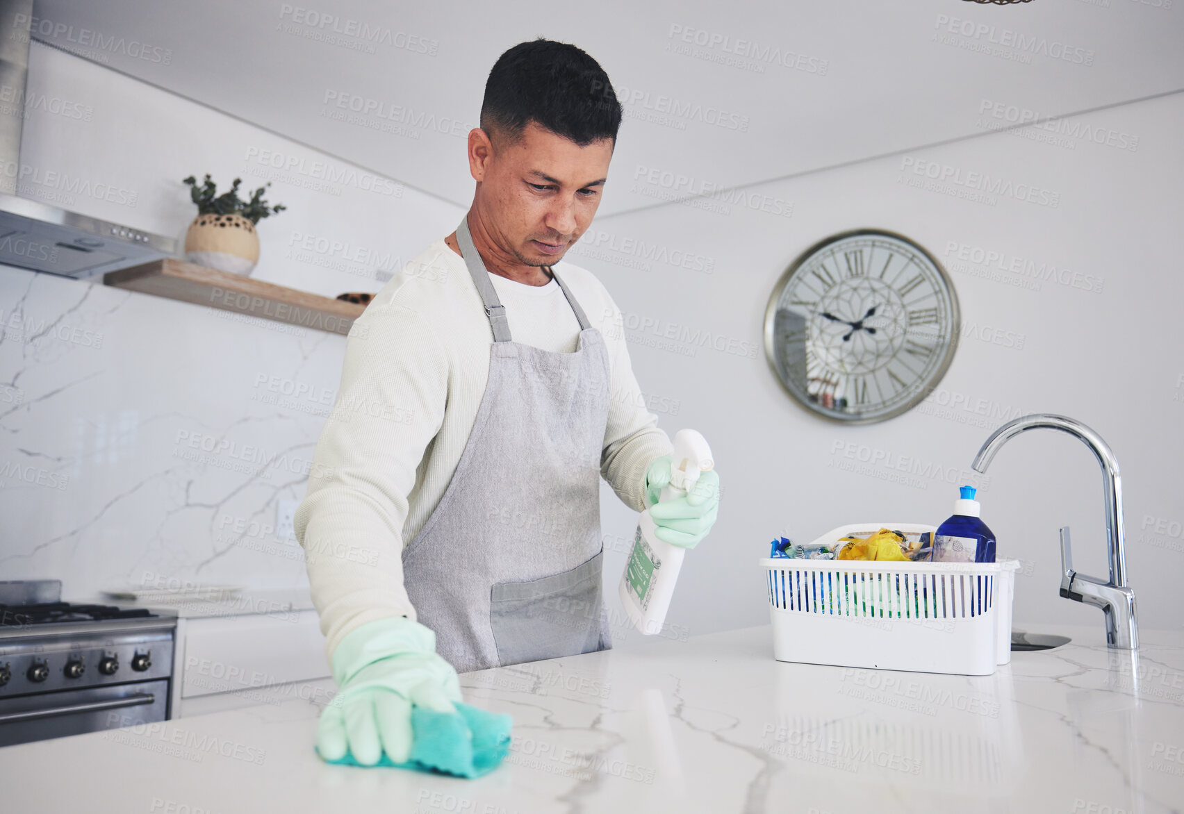 Buy stock photo Man, housekeeper and cleaning table in kitchen, hygiene or germ and bacteria removal at home. Male person, maid or cleaner wiping counter, spray bottle or cloth in sanitize, health and disinfection