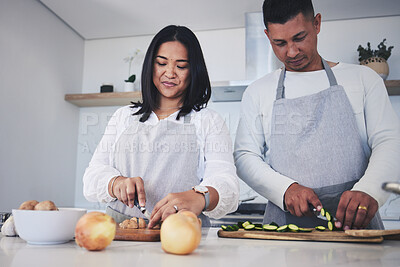 Buy stock photo Help, cooking and love with couple in kitchen for food, health and lunch recipe. Happy, nutrition and dinner with man and woman cutting vegetables at home for diet, wellness and romance together