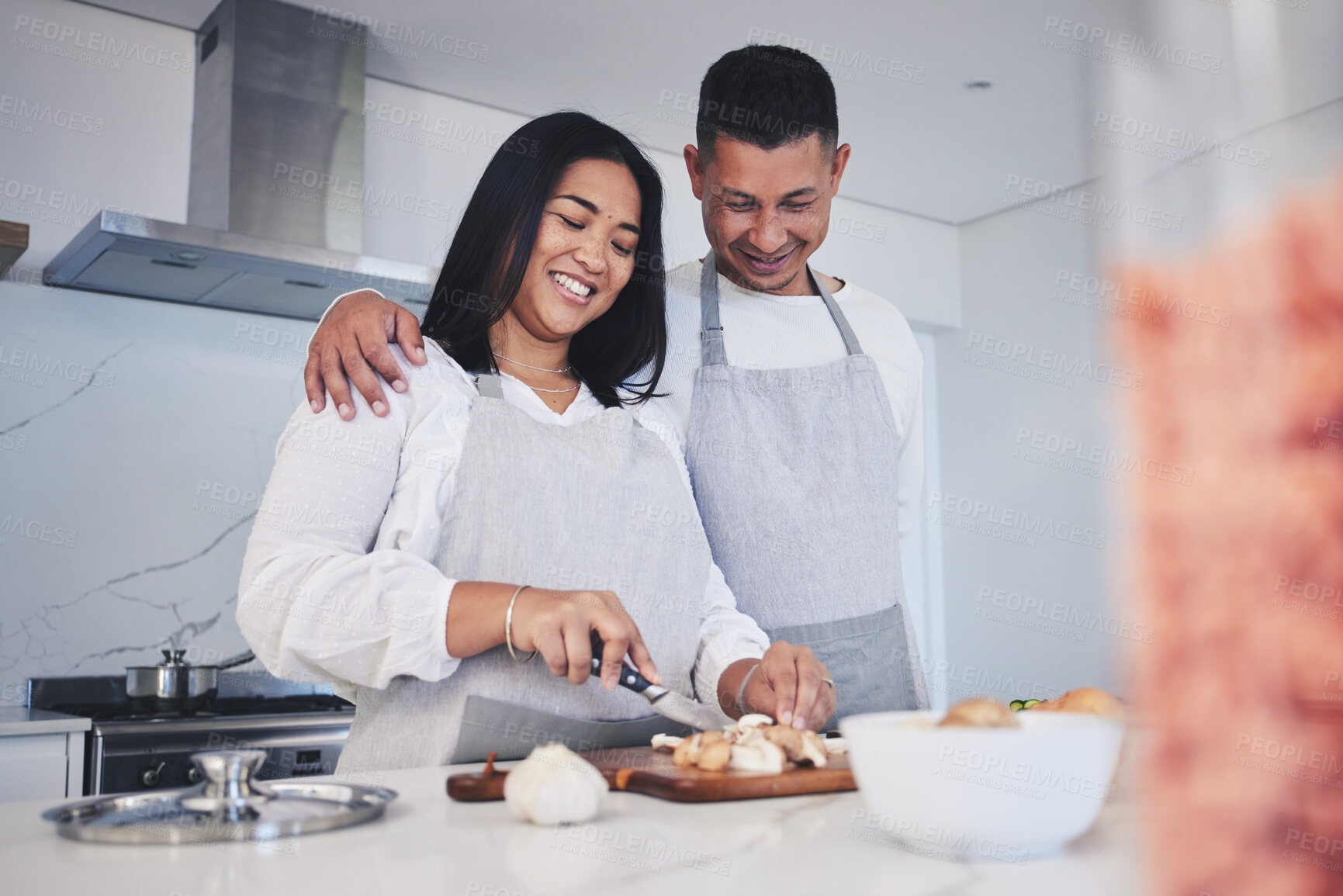 Buy stock photo Hug, cooking and love with couple in kitchen for food, health and lunch recipe. Happy, nutrition and dinner with man and woman cutting vegetables at home for diet, wellness and romance together