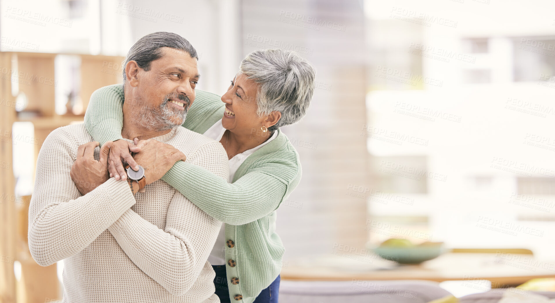 Buy stock photo Happy, hug and senior couple in a living room with love, connection and conversation in their home together. Love, smile and old people embrace in a house with romance, speaking or bond in retirement