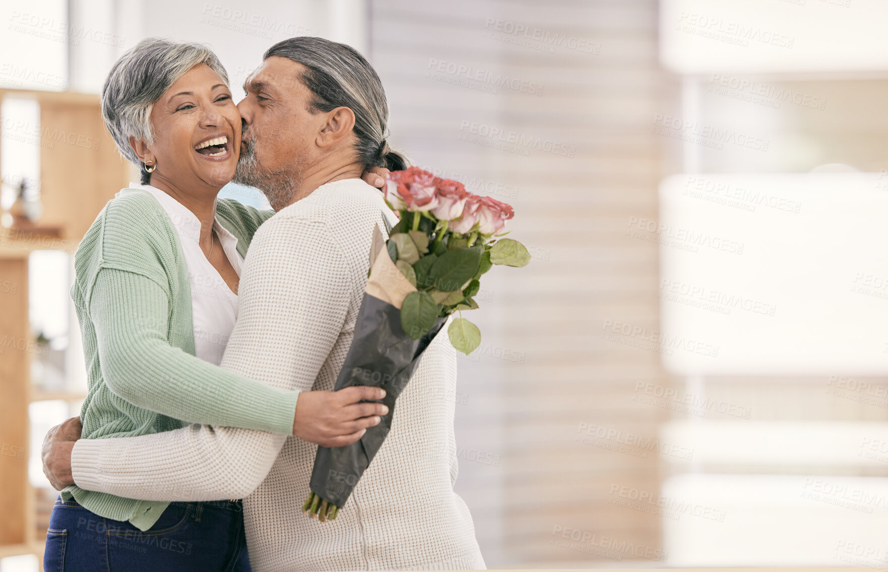 Buy stock photo Mature couple, flowers and kiss at home for anniversary, birthday or valentines celebration. Surprise, love and roses bouquet with a man and woman for healthy marriage, happiness and mockup space