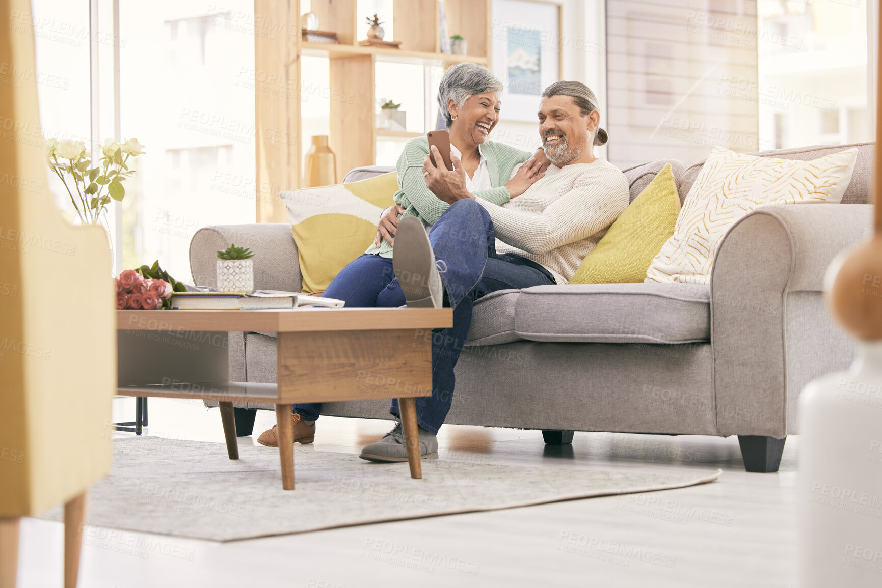 Buy stock photo Happy elderly couple, phone and relax on sofa in living room for social media or entertainment at home. Mature man and woman smile on mobile smartphone app together in happiness on couch in house