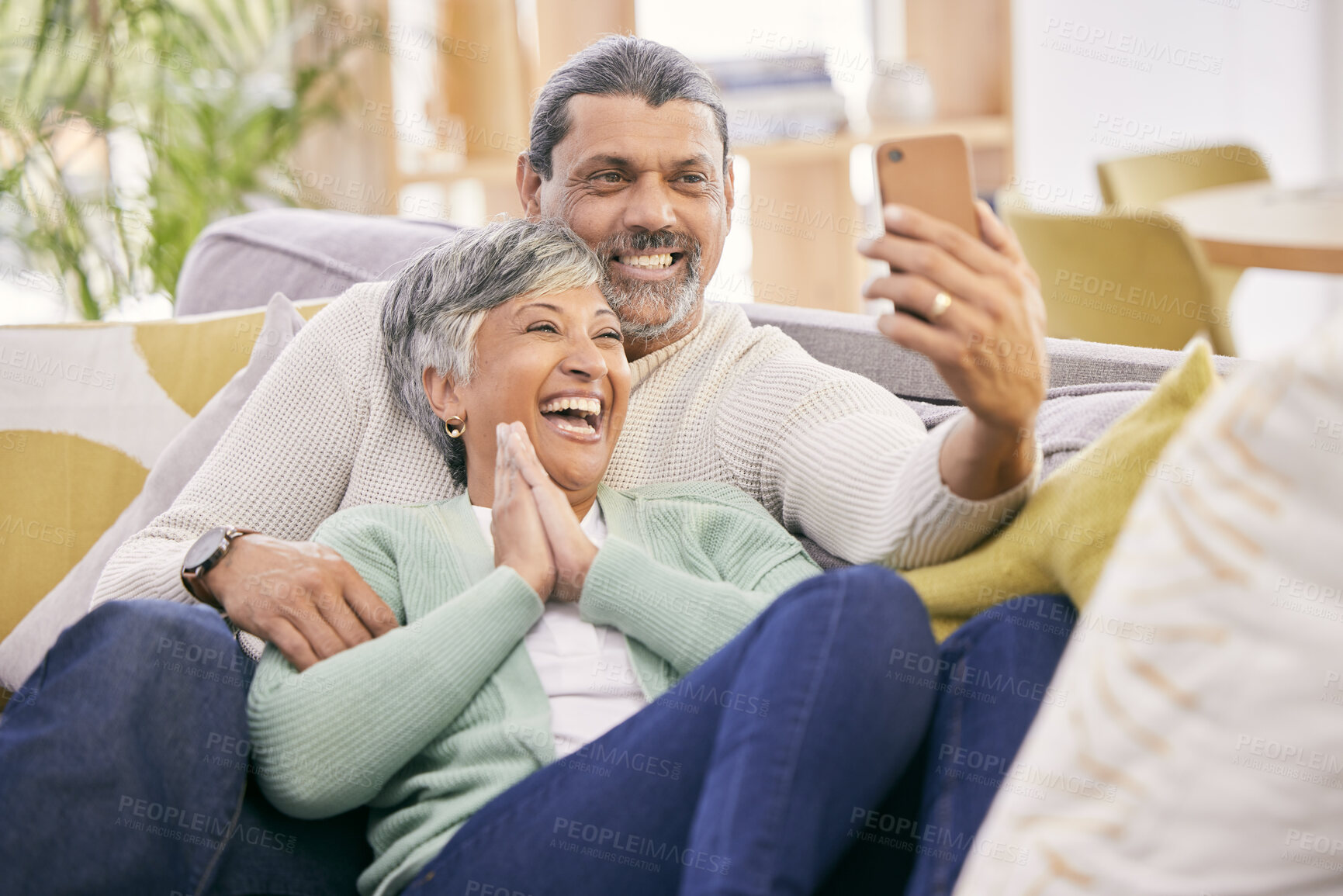 Buy stock photo Laughing, selfie and a senior couple with a phone on the sofa for communication, social media or a video call. Smile, house and an elderly man and woman taking a photo with a mobile on the couch