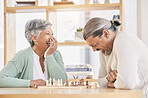 Chess, laugh and senior couple play games for relaxing, bonding and spending time together at home. Marriage, retirement and happy man and woman enjoy board game for challenge, strategy and thinking