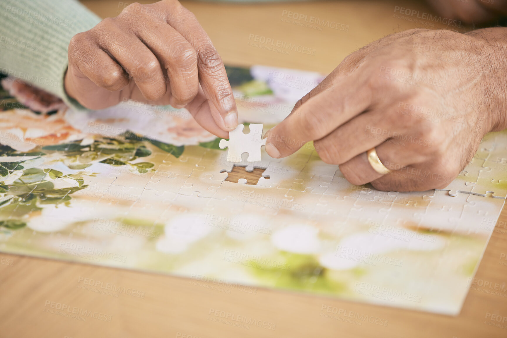 Buy stock photo Puzzle on table, piece and hands of couple in home for bonding, fun activity and relax together. Retirement, marriage and closeup of people with jigsaw for playing games, hobby and entertainment