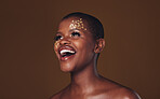 Gold, makeup and woman laughing with  beauty and luxury treatment and facial spa mask. Glitter, golden dermatology and African female person happy from skincare and golden cosmetics in studio