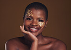 Gold, glitter portrait and black woman beauty with makeup and skincare mask in studio with sparkle cosmetics. Brown background, funny and model with golden paint for skin glow and creative shine 