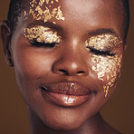 Gold, creative and black woman with makeup for beauty aesthetics isolated in a studio brown background eyes closed. Art, luxury and face of African person with cosmetic glamour or design for skincare