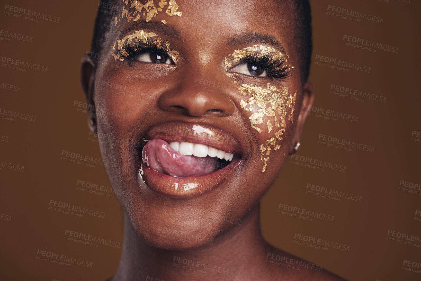 Buy stock photo Gold, glitter and black woman beauty with makeup and tongue out in studio with sparkle cosmetics. Brown background, funny and female model with golden paint for skin glow and creative facial shine 