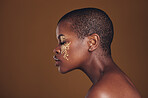 Art, profile of black woman with gold makeup and blurred background, glitter paint and cosmetics. Shine, glow and African model in studio for beauty, fashion and aesthetic freedom in luxury skincare.