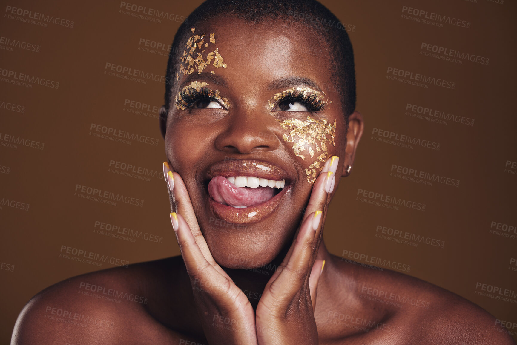 Buy stock photo Gold, glitter face and black woman beauty with makeup and tongue out in studio with sparkle cosmetics. Brown background, funny and female model with golden paint for skin glow and creative shine 