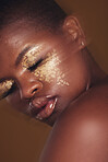 Gold beauty, blurred and black woman with eye makeup closeup with cosmetics in studio. Brown background, African female person and glitter with golden shine and glow from facial paint sparkle