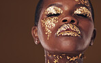 Gold, art and face of African woman with makeup for beauty aesthetics isolated in a studio brown background eyes closed. Creative, luxury and person with cosmetic glamour or design for skincare