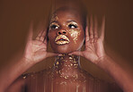 Gold beauty, makeup and black woman face with hands and blur in studio with glitter cosmetics and sparkle art. Brown background, African female model and shine from paint glow with luxury treatment