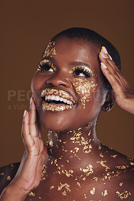 Gold, glitter flake and black woman beauty with makeup and luxury in studio  with sparkle cosmetics. Brown background, smile and female model with  golden paint for skin glow and creative facial shine