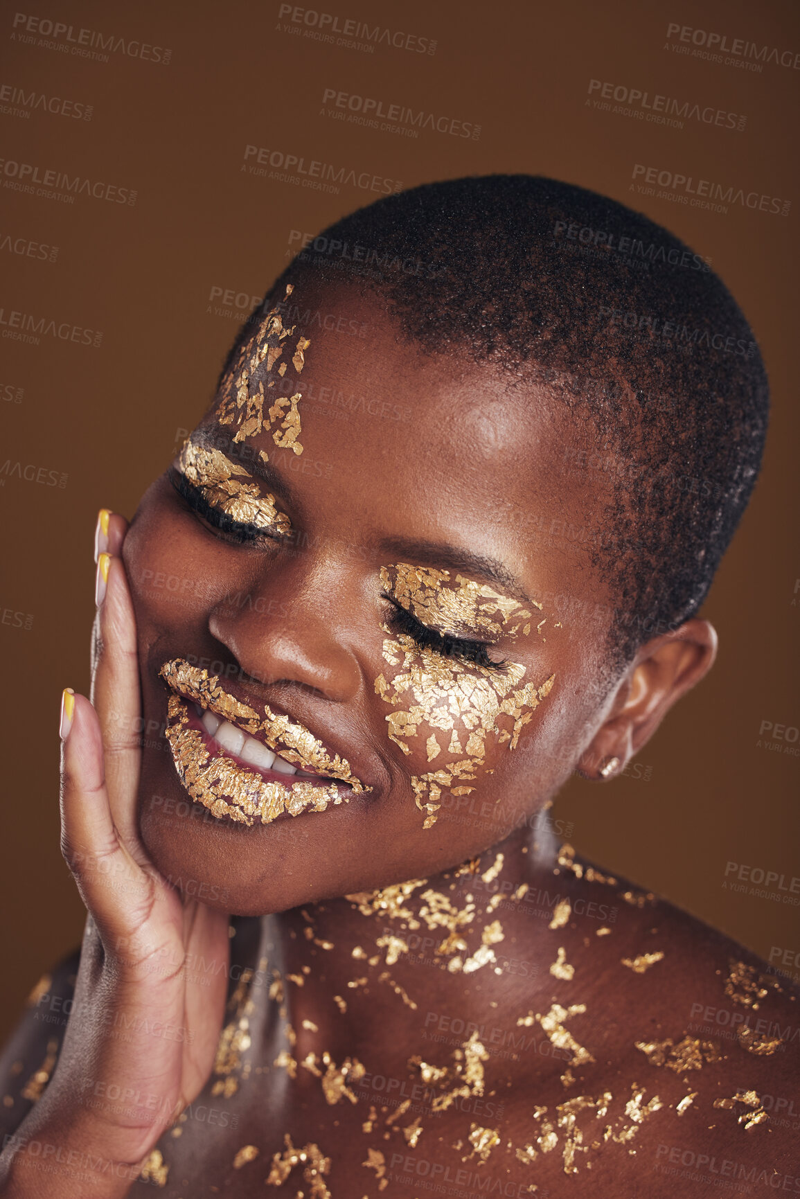 Buy stock photo Black woman, face and gold makeup with luxury glow and skincare mask with glitter. Sparkle, smile and beauty with rich and shine of cosmetics and model in studio with facial art with brown background