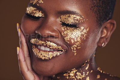 Buy stock photo Black woman, face and gold makeup closeup with luxury dermatology and skincare mask with glitter. Sparkle, smile and beauty with rich and shine of cosmetics and model in a studio with facial art