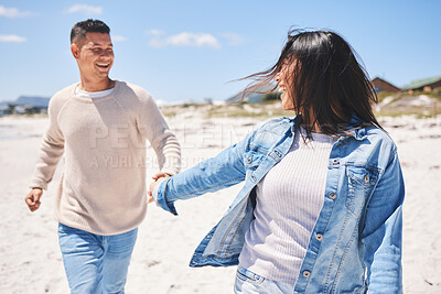 Buy stock photo Love, smile and holding hands with couple at beach for travel, summer vacation and romance together. Happy, relax and bonding with man and woman walking on seaside holiday for care, date or honeymoon