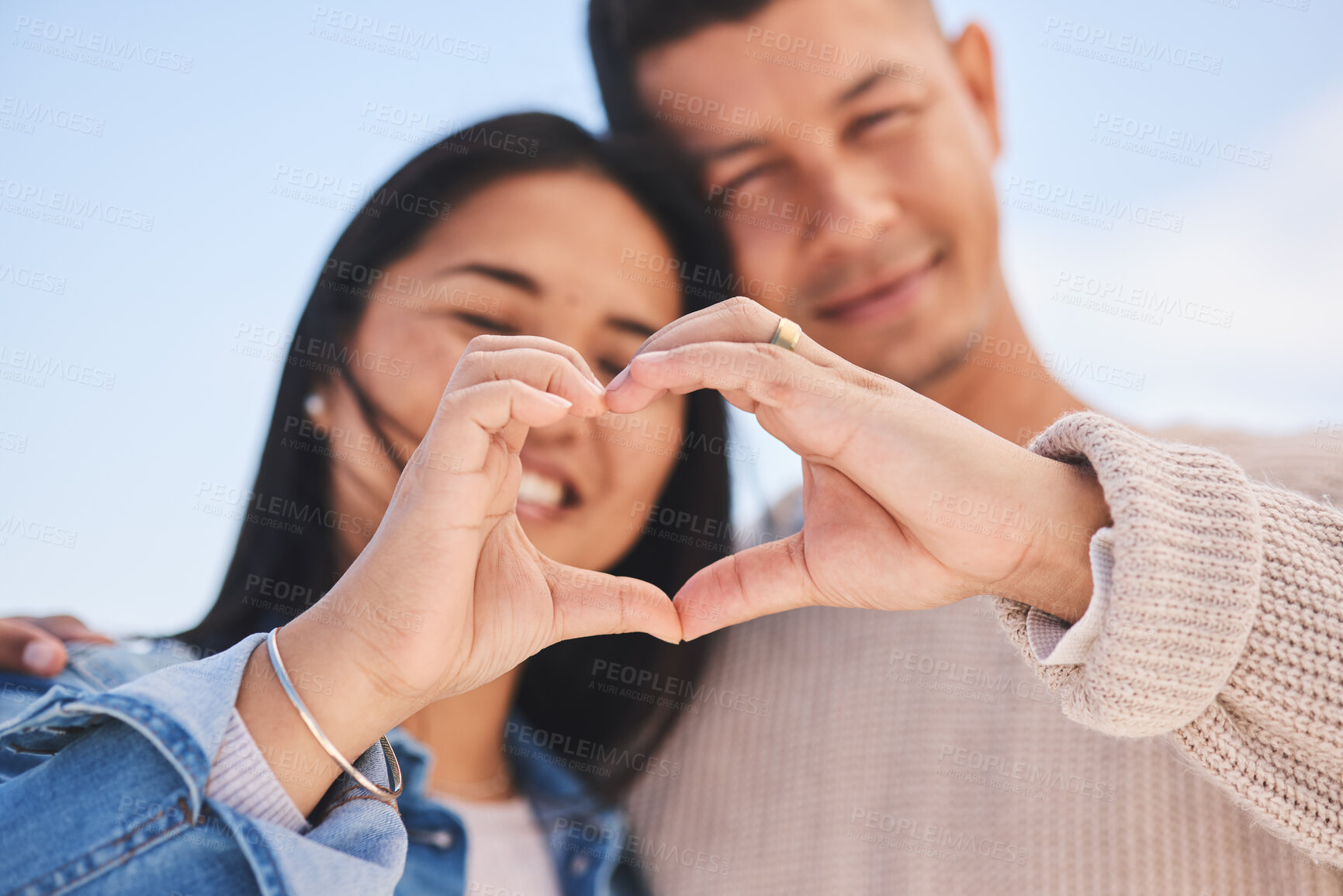 Buy stock photo Love, heart hands and portrait of happy couple with blue sky, nature and holiday travel for summer. Care, marriage and smile, loving sign language emoji with man and woman on beach vacation together.