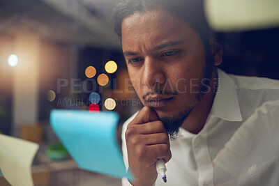 Buy stock photo Businessman, thinking and reading a note in office at night for planning a marketing strategy for professional startup in Egypt. Man, working and idea for corporate company, workplace or overtime