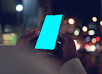 Hands, green screen on phone for communication and a business person closeup in a city at night. Marketing, contact and mockup space with an employee scrolling on a touchscreen for mobile advertising