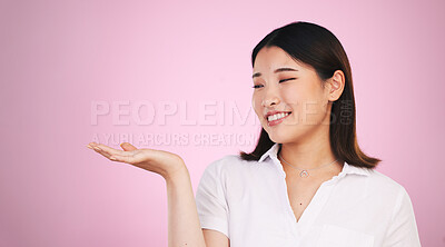 Buy stock photo Happy asian woman, palm and advertising on mockup space in marketing against a pink studio background. Female person with hands out in market show, presentation or product advertisement on mock up