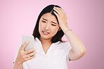 Search, phone and anxiety with face of woman in studio for networking, communication and worry. Social media, news and frustrated  with asian person on pink background for technology and mobile app