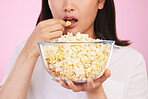 Popcorn, hungry and woman hands eating a movie snack in a studio with watching tv and food. Pink background, female person and mouth with chips in a glass bowl with film and series subscription 