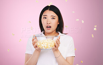 Buy stock photo Surprise, woman and portrait with horror and popcorn, bowl or food for watching tv, movies or shock for announcement. Wow, face and scared Asian model on pink background in studio with film snack 