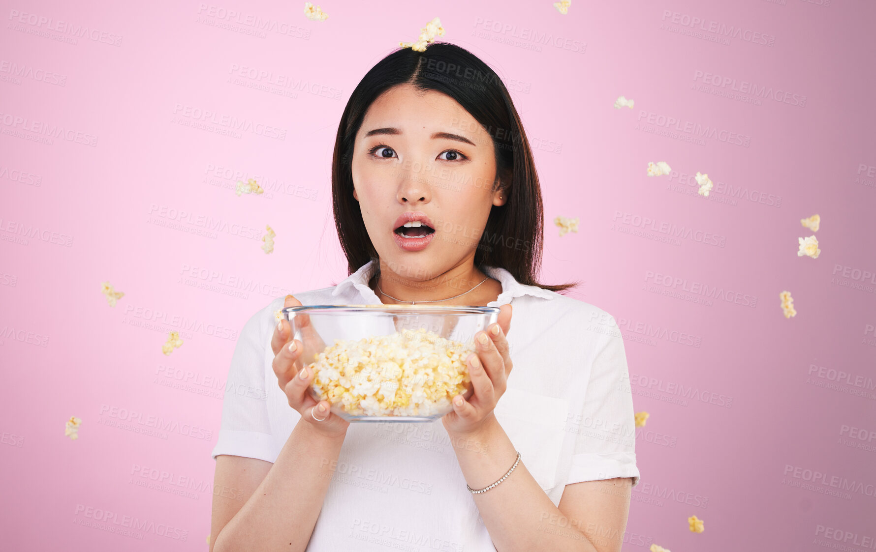 Buy stock photo Surprise, woman and portrait with horror and popcorn, bowl or food for watching tv, movies or shock for announcement. Wow, face and scared Asian model on pink background in studio with film snack 