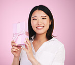 Giveaway, Asian and portrait of woman giving present box happy for celebration isolated in a studio pink background. Gift, ribbon and person with happiness for surprise or prize package with smile