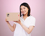 Happy asian woman, box and delivery in online shopping, supply chain or logistics against a pink studio background. Excited female person or shopper with package, parcel or cargo in ecommerce