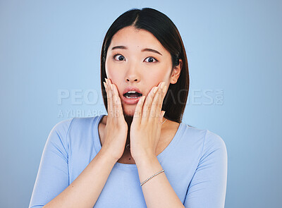 Buy stock photo Scared, portrait and Asian woman with fear from news, announcement or horror story on blue background in studio. Shock, face and person with wow, emoji or facial expression with stress or anxiety