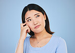 Decision, thinking and Asian woman with ideas, choice and problem solving on a blue studio background. Solution, Japanese person or model brainstorming, doubt and mockup space with questions or emoji