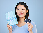 Woman, credit card and gift box, prize or retail giveaway and payment in portrait and a blue background. Happy Asian person or winner for present, finance bonus and shopping sale or success in studio