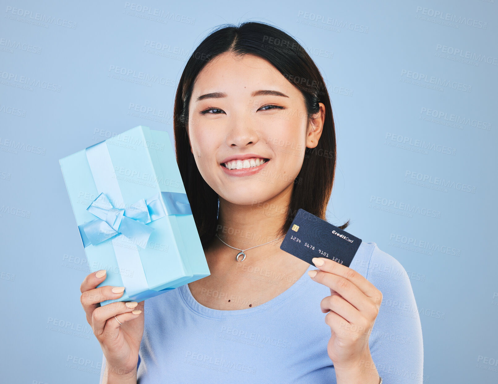 Buy stock photo Woman, credit card and gift box, prize or retail giveaway and payment in portrait and a blue background. Happy Asian person or winner for present, finance bonus and shopping sale or success in studio