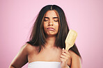 Hair care, frustrated and woman with brush ready for salon treatment in a studio. Brushing, upset and Brazilian hairstyle growth with female model from Brazil with problem and pink background