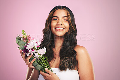Buy stock photo Happy woman, flowers and portrait in studio for skincare, natural cosmetics and aesthetic shine on pink background. Model smile for eco beauty with floral plants, sustainable  dermatology and bouquet