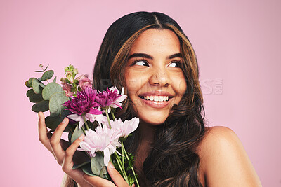 Buy stock photo Woman, flowers and bouquet in studio for skincare, cosmetics and natural aesthetic on pink background. Face, happy model and thinking of eco beauty with floral plants, sustainability and dermatology 