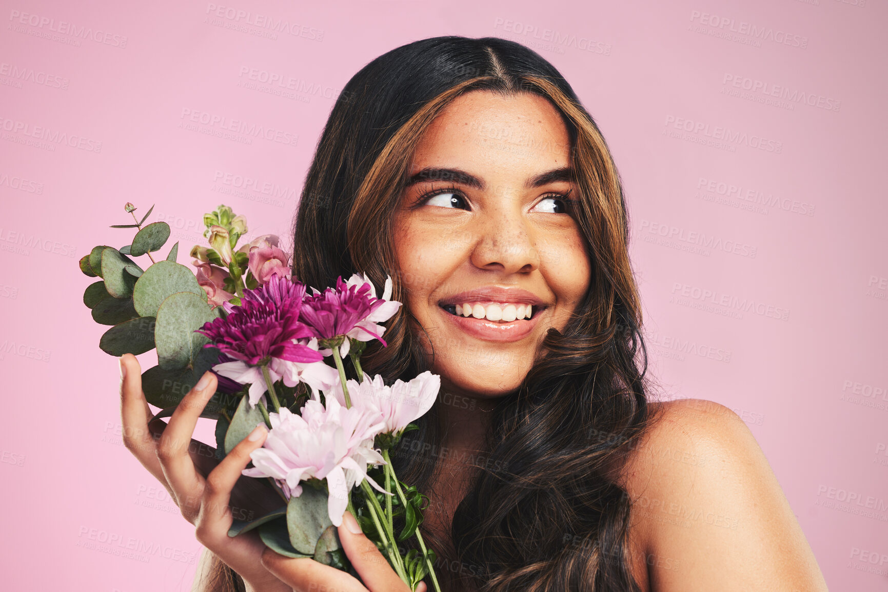 Buy stock photo Woman, flowers and bouquet in studio for skincare, cosmetics and natural aesthetic on pink background. Face, happy model and thinking of eco beauty with floral plants, sustainability and dermatology 